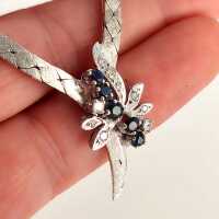 Vintage Schmuck in Weißgold - Annodazumal Antikschmuck: Vintage-Damencollier mit flacher Weißgoldkette, blütenförmigem Mittelteil mit Saphiren und Brillanten, gefertigt um 1970, mit Zertifikat
