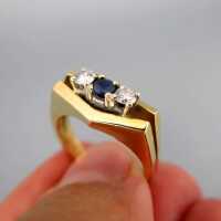 Elegant shaped ladys ring in 18 k gold with two diamonds and a deep blue sapphire