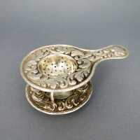 Rich decorated antique silver tea sieve with holder...