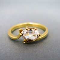 Charming womans gold ring with an oval-shaped genuine white topaz stone
