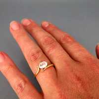 Charming womans gold ring with an oval-shaped genuine white topaz stone