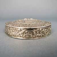 Round pill box in silver with relief bird of paradise and flower basket decor
