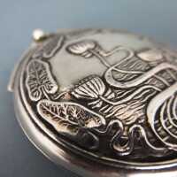 Flat round sterling silver pill box with lotus flower and leaves relief decor