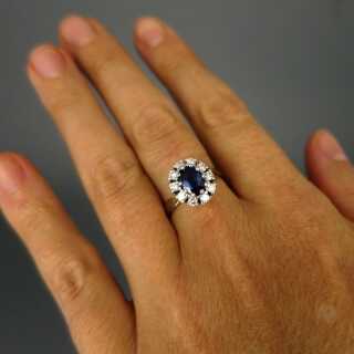 Elegant woman ring in white gold with blue sapphire and sparkly diamonds