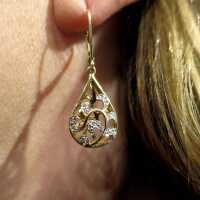 Gorgeous open worked drop shaped dangling earrings in gold with diamonds