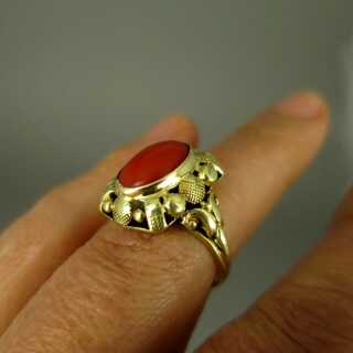 Rich decorated 14 k gold ring with an oval red coral cabochon Wilheml Müller