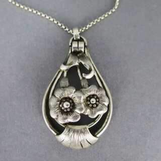 Late Art Deco pendant in open worked design silver with floral decor and chain