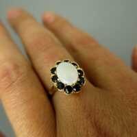 Beautiful ring in gold with an oval genuine opal and deep blue sapphire stones