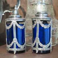 Antique salt and pepper shakers made of silver with royal blue glass inserts