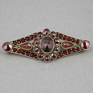 Dainty garnet brooch in elongated, floral design from the 30s