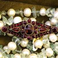 Dainty garnet brooch in elongated, floral design from the 30s
