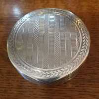 Charming round box in silver with rich decor