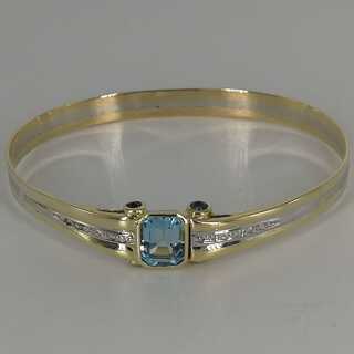 Elegant bangle in gold with a blue topaz and sapphires