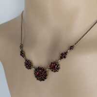 Magnificent necklace in a floral design set with deep red garnet