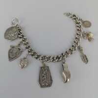 Charm bracelet in silver with many individual pendants...