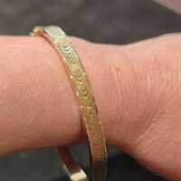 Elegant classic bangle in gold with wave pattern